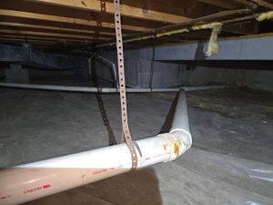 Crawl space in Avon IN with exposed ground and plumbing before vapor barrier installation
