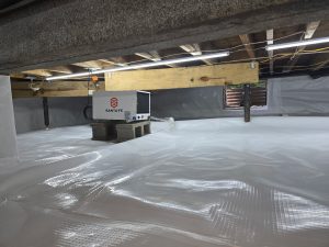 Encapsulated crawl space with a white vapor barrier and Santa Fe dehumidifier installed beneath a home.